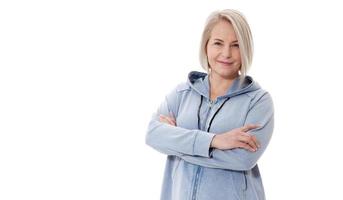 Blondine mittleren Alters posiert emotional in einem Studio. glückliche Frau im gelben hellen Pullover auf weißem Hintergrund foto