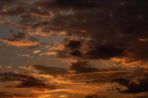 Wunderschöne Landschaft des Sonnenaufgangs oder Sonnenuntergangs mit dunklem Futter und Wolken am orangefarbenen Himmel. lebendiger und farbenfroher Hintergrund foto