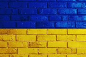 ukrainische Flagge auf einem strukturierten Hintergrund. die flagge der ukraine an der alten grunge-wand im hintergrund, das konzept der zerstörung und des krieges in der ukraine. foto