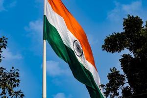 Indien-Flagge, die hoch am Connaught-Platz mit Stolz auf den blauen Himmel fliegt, Indien-Flagge flattert, indische Flagge am Unabhängigkeitstag und Tag der Republik Indien, Schuss nach oben geneigt, indische Flagge schwenkend, Har Ghar Tiranga foto