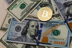 Goldene Bitcoin-Münze auf US-Dollar aus nächster Nähe foto