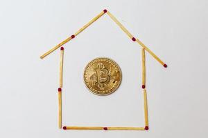 Goldenes Bitcoin auf isolierendem weißem Hintergrundkonzept Bergbauhaus, Wohnung, Kauf, foto
