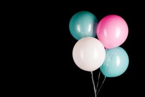 weiße blaue rosa Luftballons auf schwarzem Hintergrund foto