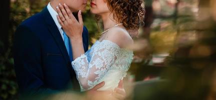 braut und bräutigam am hochzeitstag zu fuß im freien auf frühling natur brautpaar glücklich frischvermählten foto