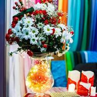 ein Strauß Kamille und Rosen in einer Vase foto