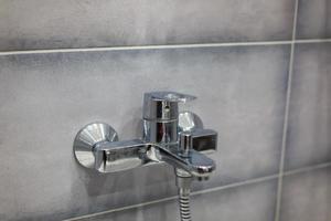 Edelstahlhahn auf modernem Hintergrund im Badezimmer foto