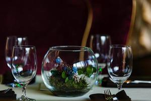 leere Gläser in Restaurantgläsern im Restaurant auf den Tischblumen foto