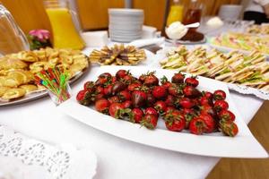 Frische Erdbeeren, eingetaucht in dunkle Schokolade auf blauem Holzhintergrund foto