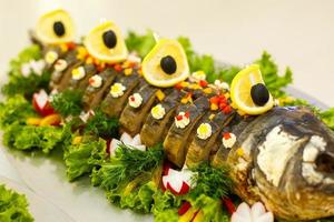 gefilte fisch,gefilte fisch auf dem teller closeup.delicious gefüllter karpfen mit zitrone.fisch karpfen gefüllt.gefüllter fisch mit salatblättern. foto