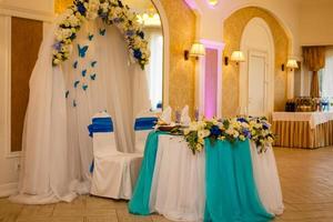 Hochzeitsdekoration von Tisch und Stühlen von Braut und Bräutigam mit Blumen und Tüll foto