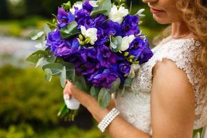 Brautstrauß blau mit weißen Blumen in den Händen der Braut. foto