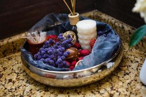 badezimmerinnenraum mit komposition der spa-behandlung mit handtüchern, kerzen und anderem accessoires. Weißes Porzellanwaschbecken im luxuriösen Badezimmer. foto