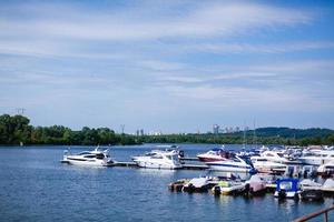 am Ufer des Flusses verankerte Boote, jenseits des Flusses Wohnhäuser, breiter Fluss, Rastplatz foto