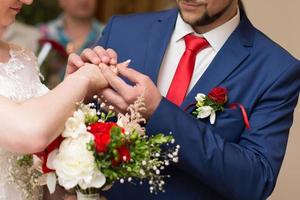 das brautpaar tauscht die ringe während einer hochzeitszeremonie, einer hochzeit im sommergarten foto