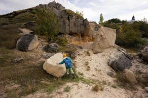 junge erkunden kalksteine am berg in pidkamin, ukraine. foto