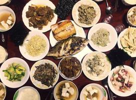 koreanischer Esstisch mit vielen Arten von Banchan-Beilagen, koreanische Esskultur foto