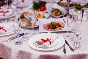 servierter Tisch im Restaurant mit Geschirr und Gläsern foto