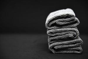drei graue Handtücher auf schwarzem Hintergrund. Frotteetücher zum Abwischen von Möbeln. Handtücher auf schwarzem Hintergrund. foto
