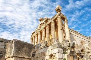 Säulen des antiken römischen Bacchustempels mit umliegenden Ruinen und blauem Himmel im Hintergrund, Beqaa-Tal, Baalbeck, Libanon foto