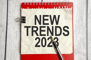 Trends 2023 Text auf Papier mit rotem Notizbuch und Stift foto