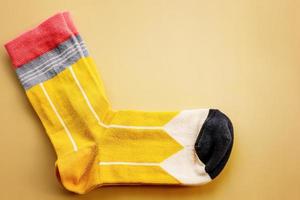 gelbe Socken auf beigem Hintergrund. ein Paar gestreifte Socken.