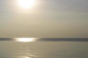 wunderbarer sonnenuntergang in der meerwasseroberfläche am abend am ban foto