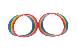 Zwei bunte Regenbogen-Armbänder, LGBTQ-Personen-Symbol in seltsamer Form isoliert auf weißem Hintergrund mit Beschneidungspfad. konzept des lgbtq-armbandes, das getragen wird, um lgbtg-feierveranstaltungen zu unterstützen und daran teilzunehmen foto