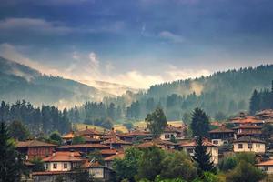 Nebellandschaft Bergblick über die schönen Holzhäuser des Dorfes foto
