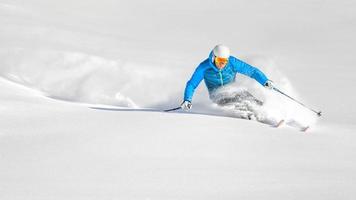 Skifahrer im Pulverschnee während einer Carving-Kurve foto