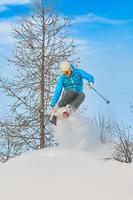 Skifahrer springt in den Tiefschnee foto