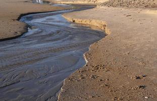 schöner goldener sandstrand und wasserlinie kanal sonnenaufgang frische meeresbrise sommerferien. foto