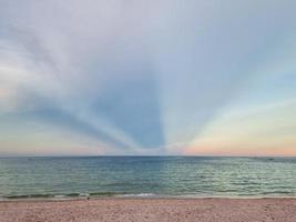 Wunder Sonnenlicht Sonnenuntergang dreifache Form am Himmel. goldener sandstrand klarer blauer himmel in thailand foto