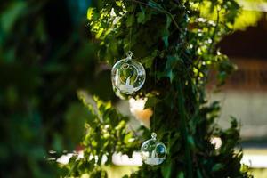 origineller Hochzeitsblumenschmuck in Form von Minivasen und Blumensträußen, die von der Decke hängen foto