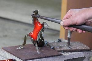 Der Meister arbeitet mit Glas in einer Glasfabrik. foto