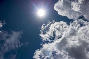 Landschaftshintergrund mit weißen Wolken, die in der Nähe der hellen Sonnenstrahlen treiben. foto