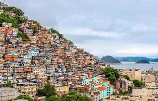 brasilianische favelas auf dem hügel mit innenstadt unten an der tropischen bucht, rio de janeiro, brasilien foto