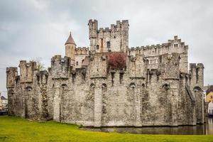 Festungsmauern und Türme der mittelalterlichen Burg Gravensteen mit Wassergraben im Vordergrund, Gent, Ostflandern, Belgien foto