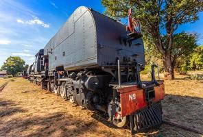 Alte Lokomotive aus Retro-Stahl, die auf den Schienen in Livingstone, Sambia, steht foto