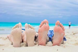 Closeup männliche und weibliche Füße auf weißem Sand foto