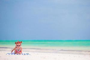 entzückendes kleines mädchen genießt sommerferien am strand foto