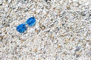 Nahaufnahme von bunten blauen Sonnenbrillen am tropischen Strand foto