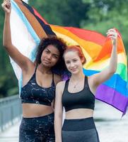 zwei lesbische menschen freundschaft mit regenbogenstolzflagge. Fröhliche schwule Person, die Spaß zusammen mit Gleichberechtigung in Bezug auf Liebe und Freiheit hat. vielfalt junger homosexueller paare, lgbtq-rechte. foto