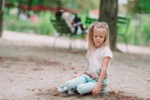 entzückende Mode kleines Mädchen im Freien in den Tuileries-Gärten, Paris foto