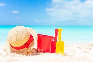 Strandspielzeug für Kinder und Strohhut am weißen Sandstrand foto