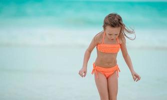 kleines Mädchen am Strand während der Sommerferien foto