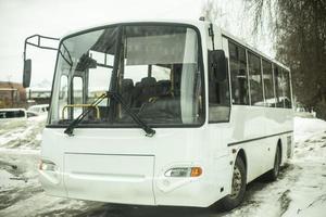 weißer Bus auf dem Parkplatz. öffentliche Verkehrsmittel im Winter. foto