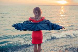 Outdoor-Modeporträt eines stilvollen Mädchens mit Jeansjacke am Strand. foto