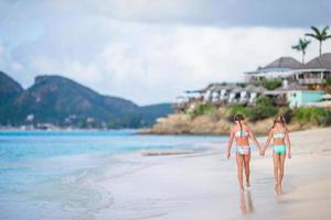 Zwei kleine glückliche Mädchen haben viel Spaß am tropischen Strand und spielen zusammen foto