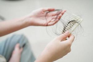 asiatische frau hat ein problem mit langem haarausfall in der hand. foto