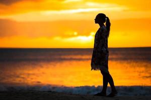 schöne Frau am weißen Strand bei Sonnenuntergang. foto